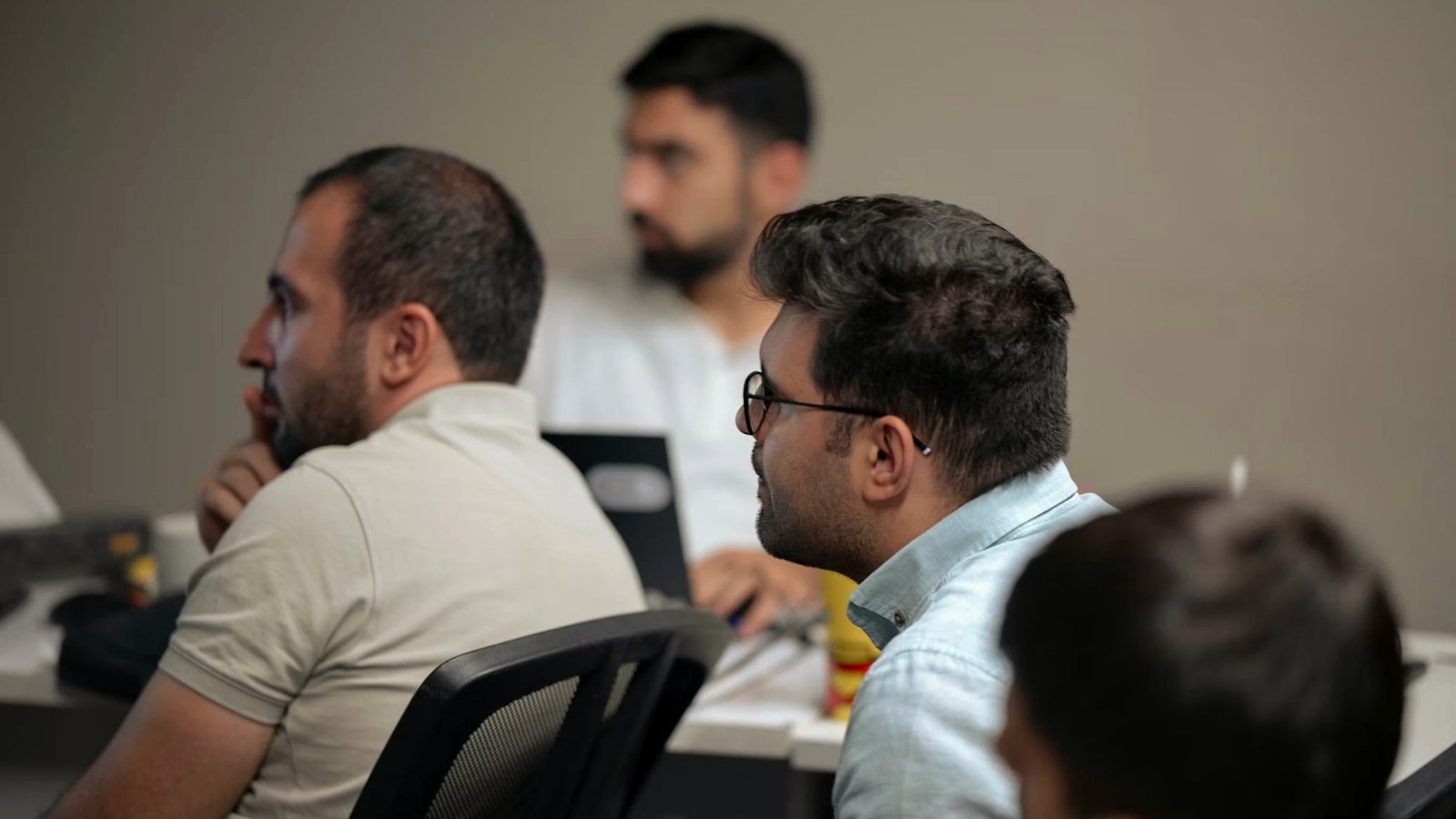 AI training academy cohort working on laptops